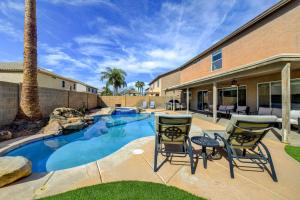 un patio trasero con piscina y 2 sillas en Spacious Arizona Home Pool, 9 Mi to San Tan Mtn, en Queen Creek