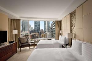 a hotel room with two beds and a large window at Shangri-La Toronto in Toronto