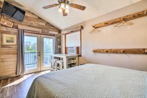 Schlafzimmer mit einem Bett, einem Deckenventilator und einem Fenster in der Unterkunft Guadalupe River Cottage with Direct Lake Access! in Seguin