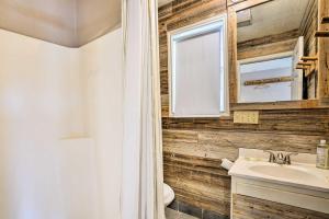a bathroom with wooden walls and a sink and a mirror at Guadalupe River Cottage with Direct Lake Access! in Seguin