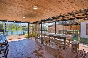 a patio with benches and a wooden ceiling at Guadalupe River Cottage with Direct Lake Access! in Seguin
