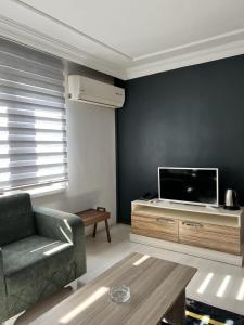 a living room with a couch and a flat screen tv at Bahem Rezidans in Samsun