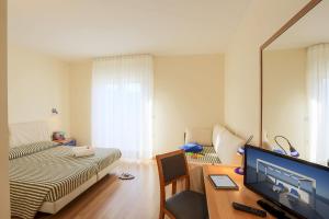 a bedroom with a bed and a desk with a television at Hotel Sporting in Casalbordino