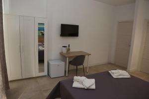 Schlafzimmer mit einem Schreibtisch und einem Bett mit Handtüchern in der Unterkunft B&B La Dimora di Nonno Lucio in Pozzuoli