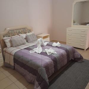 a bedroom with a bed with shoes on it at Apartment Mitrou 2 in Loutra Oraias Elenis 