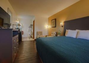 una camera d'albergo con un letto e una televisione di Shady Acre Inn and Suites a Branson West Altre 22 foto