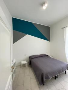a bedroom with a bed with a blue accent wall at alloggio turistico P. Fontana Grande in Viterbo