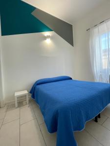 a bedroom with a blue bed and a window at alloggio turistico P. Fontana Grande in Viterbo