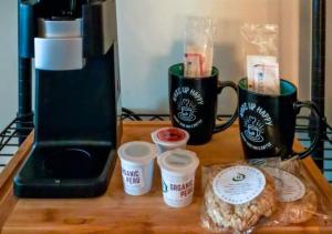 a table with coffee cups and a bagel and a coffee maker at Shady Acre Inn and Suites in Branson West