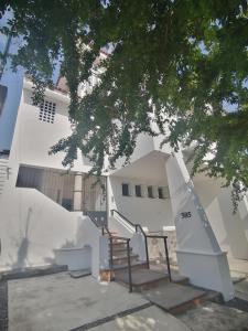 - un bâtiment blanc avec des escaliers devant dans l'établissement Htl & Suites Neruda, ubicación, limpieza, facturamos, à Colima