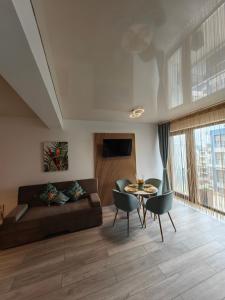 un soggiorno con un divano e un tavolo di ELLA by Complex Almar Luxury a Mamaia Nord - Năvodari