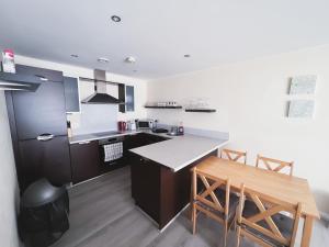 cocina con encimera, mesa y sillas en Spacious 2 Bed Flat, Free Parking, Close to town, en Mánchester