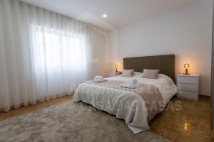 een slaapkamer met een groot bed met witte gordijnen bij Moinho D'ouro Residence by ACasaDasCasas in Ericeira