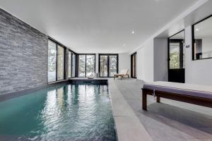 una piscina cubierta en una casa con ventanas en Chalet du Bois Melay 5 étoiles - La Plagne 1800 - piscine - proche pistes - 15 personnes, en Plagne 1800