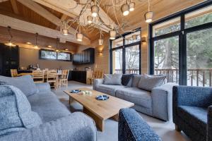 una sala de estar con sofás azules y una mesa. en Chalet du Bois Melay 5 étoiles - La Plagne 1800 - piscine - proche pistes - 15 personnes en Plagne 1800