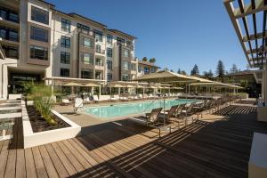 a pool with chairs and umbrellas next to a building at Mountain View 1br w wd pool gym nr tech HQs SFO-1183 in Sunnyvale