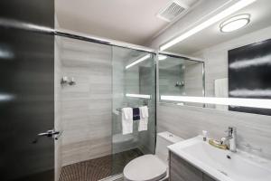 uma casa de banho com um chuveiro, um WC e um lavatório. em Venezia em Miami Beach