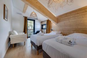 sypialnia z dwoma łóżkami i krzesłem w obiekcie Chalet du Bois Melay - piscine - proche pistes - 15 personnes w mieście Plagne 1800 +22 zdjęcia
