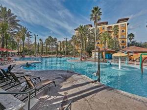 a large swimming pool with palm trees and buildings at Designer Corner Suite 3br/2ba - Disney, Universal, Convention Center & SeaWorld in Orlando