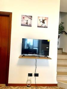 TV de pantalla plana en una pared blanca en Casa Vacanze Ca' di Lucchini, en San Benedetto Val di Sambro