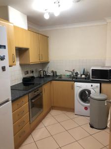 a kitchen with a sink and a washing machine at Basingstoke by train station in Basingstoke