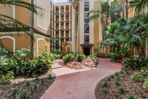 un edificio con un patio con palmeras y una pasarela en Designer Corner Suite 3br/2ba - Disney, Universal, Convention Center & SeaWorld en Orlando