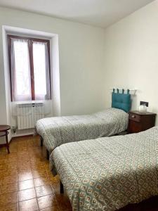 a room with three beds and a window at Casa Vacanze Ca' di Lucchini in San Benedetto Val di Sambro