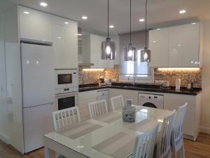 a kitchen with a table and white appliances at Villa MyRuedo in Fuengirola