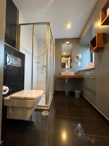 een badkamer met een douche, een toilet en een wastafel bij A Finca Hotel in Barreiros