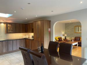 a kitchen and living room with a table and chairs at Meadow View Apartment in Belcoo
