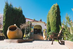 een huis met een grote vaas en een bank voor bij Hotel Rural El Refugio in Tejeda