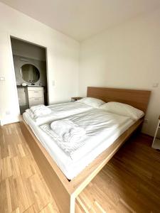 uma grande cama branca num quarto com piso em madeira em FORSTHAUS 32 FREE GARAGE em Viena