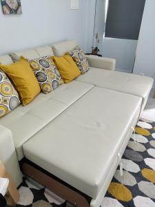 Un sofá blanco con almohadas en una habitación. en Riviera Beach B, en Praia da Vitória
