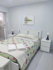 biała sypialnia z łóżkiem i ręcznikami w obiekcie Riviera Beach B w mieście Praia da Vitória