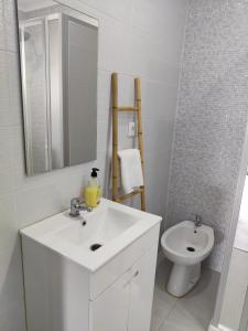 biała łazienka z umywalką i toaletą w obiekcie Riviera Beach B w mieście Praia da Vitória