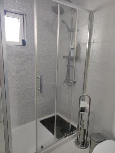 W łazience znajduje się prysznic ze szklanymi drzwiami. w obiekcie Riviera Beach B w mieście Praia da Vitória