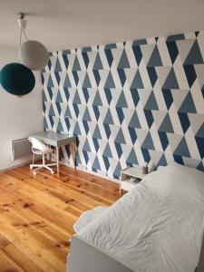 Le loft في نيس: غرفة نوم بحائط ازرق وابيض مع سرير ومكتب