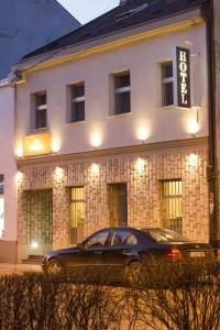 un coche negro estacionado frente a un edificio en Hotel Ideja, en Banja Luka