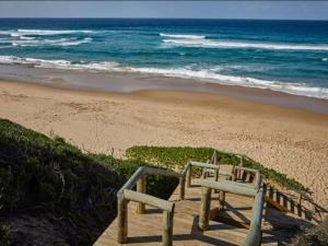 Ponta Membene في Machavene: درج خشبي يؤدي إلى شاطئ مع المحيط
