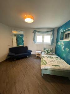 a bedroom with a bed and a couch and a window at Rheintal-Wald-und Weitsicht in Rengsdorf