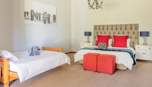 um quarto com 2 camas em vermelho e branco em Hopefield BnB em Addo