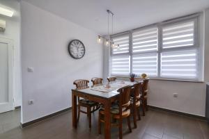 a dining room with a table and chairs and a clock at Studio Apartment Harbour Pula in Pula