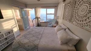 een slaapkamer met een groot bed en uitzicht op de oceaan bij Seaside Tresure. in Mosselbaai