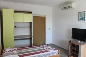a small room with a bed and a television at Blanka Apartment in Orebić