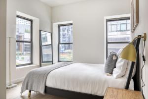 - une chambre avec un lit et trois fenêtres dans l'établissement Downtown BK 2BR w Terrace WD nr Barclays NYC-658, à Brooklyn