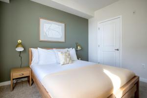 een slaapkamer met een groot wit bed en een deur bij NoMa 1BR w Gym Doorman nr Capitol Hill WDC-209 in Washington