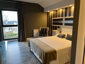 een slaapkamer met een bed, een stoel en een raam bij A Finca Hotel in Barreiros