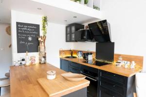 een keuken met een houten aanrecht en een zwart aanrecht bij Maison chaleureuse à 5 mins des remparts in Aigues-Mortes