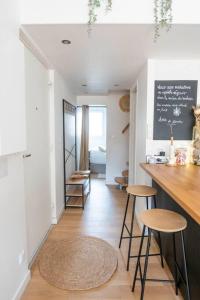 a kitchen with a counter and stools in a room at Maison chaleureuse à 5 mins des remparts in Aigues-Mortes