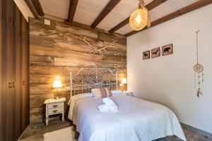 a bedroom with a white bed and a wooden wall at Hostal Avenjúcar in Tolosa